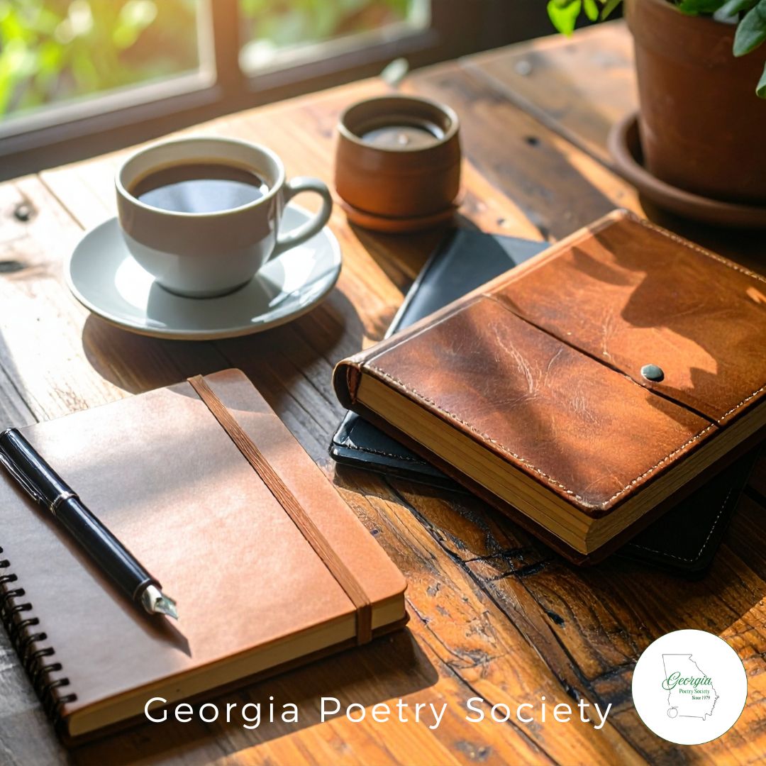 An open notebook and pen on a kitchen table beside a cup of coffee, with everyday household clutter in the background